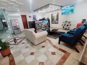 Gran Hotel Cali في كالي: غرفة معيشة مع كرسيين وطاولة