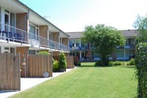 a building with a fence and a yard at Appartement Walvis nr. 20 in Vrouwenpolder