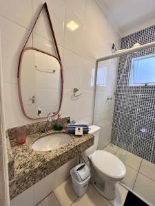 La salle de bains est pourvue d'un lavabo, de toilettes et d'un miroir. dans l'établissement Nossa Casa, Sua Casa 02 - Excelente Localizacao, à Parati
