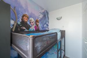 a bedroom with a bed with a painting on the wall at Rainbow Duplex N°1 Disney in Serris