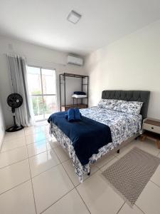 1 dormitorio con 1 cama grande con manta azul en Nossa Casa, Sua Casa 02 - Excelente Localizacao, en Paraty