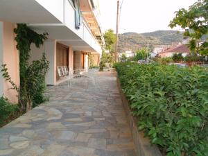 una pasarela de piedra junto a un edificio con sillas en Kochili Apartments, en Néos Pírgos