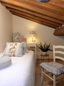 a bedroom with a bed and a table and a chair at Casetta nel bosco - L'Antico Metato in Pierle