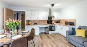 a kitchen and living room with a table and a couch at High Range Holiday Apartments in Aviemore