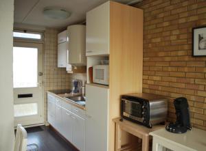 a small kitchen with a microwave on a table at Appartement Walvis nr. 26B in Vrouwenpolder
