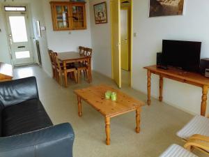 een woonkamer met een salontafel en een televisie bij Appartement Walvis nr. 9H in Vrouwenpolder