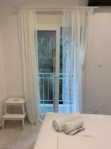 um quarto com uma cama e uma grande janela em George House em Atenas