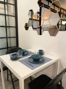 a white table with plates and cups on it at CRIB 252 Subic Bay in Subic