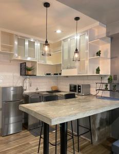 a kitchen with white cabinets and a marble counter top at CRIB 252 Subic Bay in Subic