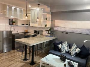 a kitchen and living room with a blue couch at CRIB 252 Subic Bay in Subic