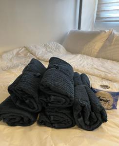 una pila de toallas negras en una cama en CRIB 252 Subic Bay en Subic