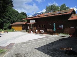 a building with a patio in front of it at Chalet Waldstadl, Andrea's Woidhaisl in Arnbruck