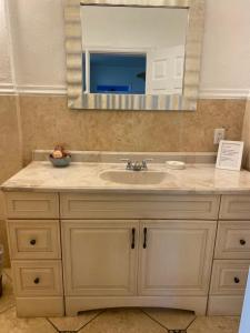 a bathroom with a sink and a mirror at The Inn at Turtle Beach (Adults Only) in Siesta Key