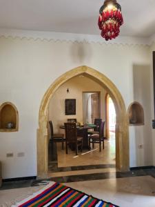 comedor con mesa, sillas y lámpara de araña en Villa Louiza en Mezraya