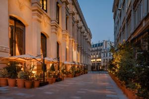 eine leere Straße mit Sonnenschirmen und Topfpflanzen in der Unterkunft Hôtel Madame Rêve in Paris