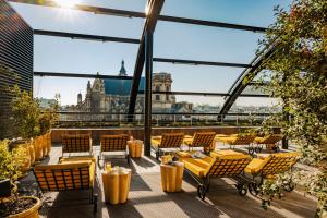 a rooftop patio with chairs and tables and a view of the city at Hôtel Madame Rêve in Paris