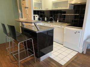 a kitchen with a sink and a counter with chairs at Appartement Le Temple Auxerre Centre Ville in Auxerre