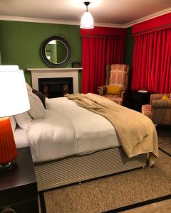 1 dormitorio con cama, silla y espejo en The Inn at Loch Tummel, en Tummel Bridge