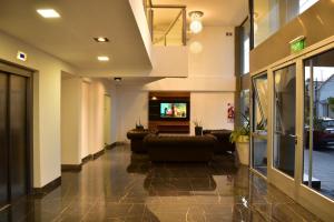 a lobby with couches and a tv in a building at La Gioconda Apart Hotel in Villa María