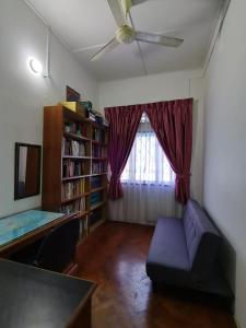 een woonkamer met een plafondventilator en een bank bij TS GUEST HOUSE in Kuantan