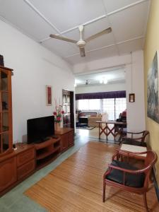 een woonkamer met een flatscreen-tv en een bank bij TS GUEST HOUSE in Kuantan
