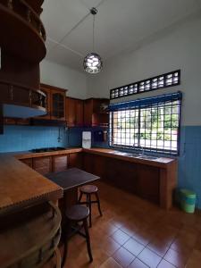 een keuken met een tafel en twee krukken. bij TS GUEST HOUSE in Kuantan