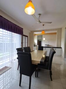 a dining room with a wooden table and black chairs at TS GUEST HOUSE in Kuantan +3 photos