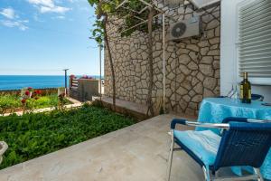 a table and chairs on a patio with a view of the ocean at Guesthouse Home Sweet Home in Dubrovnik