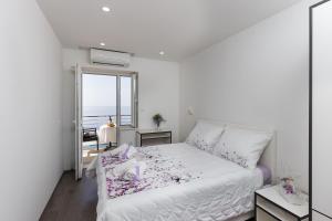 Cama blanca en habitación con ventana en Guesthouse Home Sweet Home, en Dubrovnik
