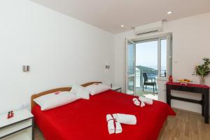 a bedroom with a red bed with a red blanket at Guesthouse Home Sweet Home in Dubrovnik