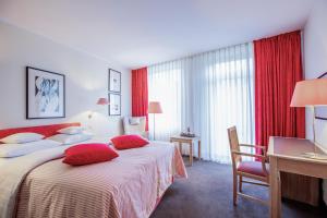 a hotel room with two beds and a desk at Romantik Hotel Landschloss Fasanerie in Zweibrücken