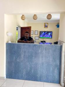 a man sitting at a bar looking at his cell phone at Elephant View Lodge & Apartments in Livingstone +57 photos