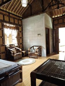 - une chambre avec deux chaises et un lit dans l'établissement Pondok Bamboo Sendangsari, à Wonosobo