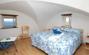 Un dormitorio con una cama y una mesa con un ordenador portátil. en Da Rita en Amalfi