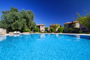 una grande piscina blu con case sullo sfondo di Saint Thomas Village a Città di Lefkada