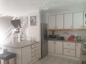 a kitchen with white cabinets and a stainless steel refrigerator at 5 bedroom home in Langebaan, located close to Club Mykanos and Laguna Mall in Langebaan