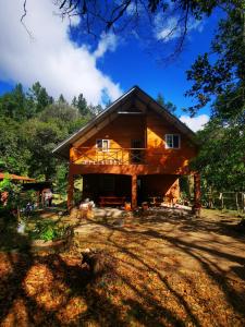 a large wooden house in the middle of a yard at La Yeguada - Forest Point Cabin in El Quije
