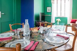 una sala da pranzo con tavolo e piatti di Furnished Townhouse Ideally Located With 4 Bedrooms Large Terrace & Garden a Le Bouscat