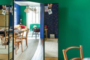 comedor con paredes verdes, mesa y sillas en Furnished Townhouse Ideally Located With 4 Bedrooms Large Terrace & Garden, en Le Bouscat