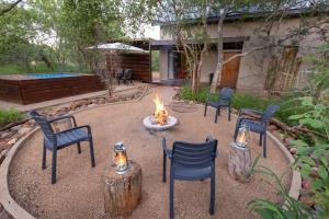 a fire pit in a yard with chairs and a fire place at Wildheart Safari - Zesty Zebra in Hoedspruit