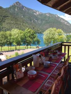 a table on a balcony with a view of a mountain at Casa Monica Ledro Attico in Mezzolago