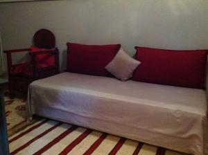 a bed with two red pillows on it in a room at Riad Syba in Marrakesh