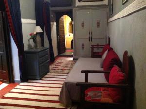 1 dormitorio con 1 cama y 1 silla en una habitación en Riad Syba, en Marrakech