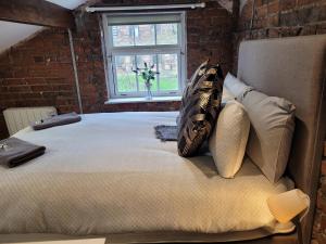 ein großes Bett in einem Zimmer mit Ziegelwand in der Unterkunft Carlisle Central, Cute Studio Appt, The Cupboard in Carlisle