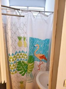 una tenda da doccia con fenicottero in bagno di Appartement d'une chambre avec jardin clos et wifi a Sainte Rose a 2 km de la plage a Sainte-Rose
