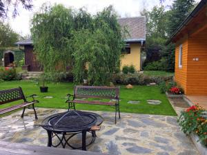 a patio with two benches and a table in a yard at Penzion Maruška in Dolní Moravice