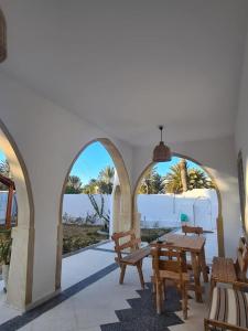 un patio con mesa y sillas y vistas al océano en Villa Louiza en Mezraya