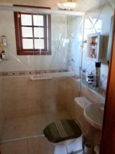 a bathroom with a shower and a toilet and a sink at Confortável Casa de Campo em Condomínio Fechado in Águas de Lindóia