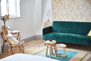 a green couch in a living room with two stools at Demeure de Manneville - SPA - 1Km des plages de Cabourg in Dives-sur-Mer