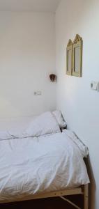 a bed in a room with a white wall at Sterrenhoeve in Castricum